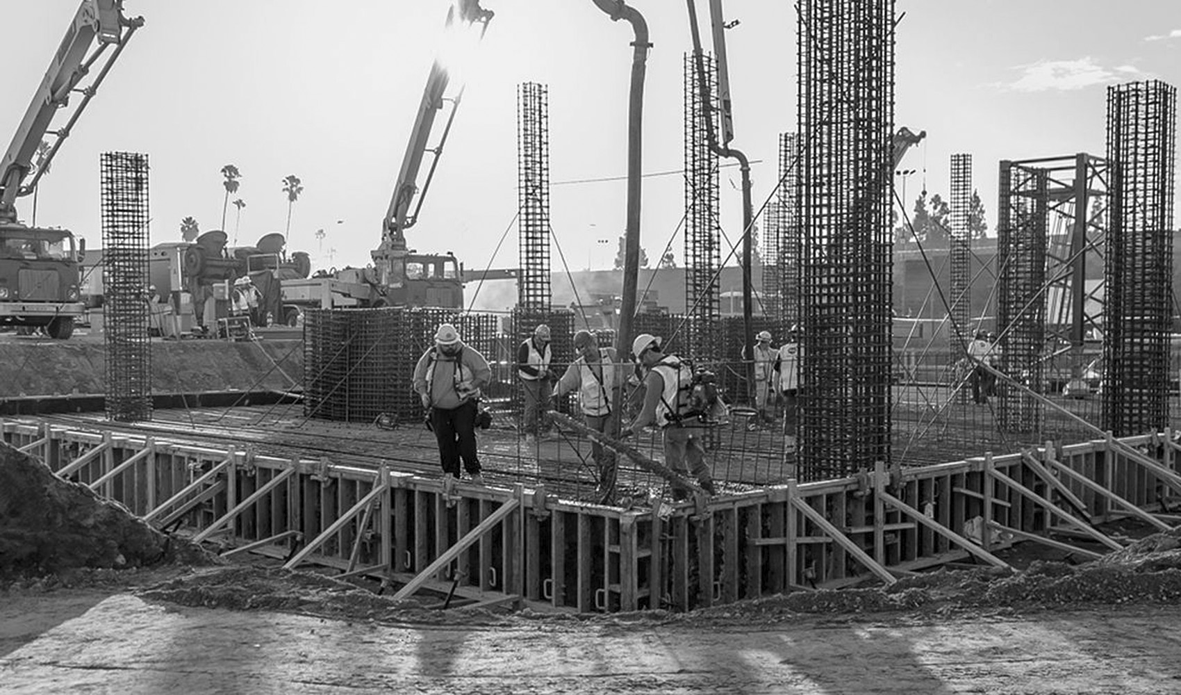 Illustrative construction site with coordinated structural lifting operations